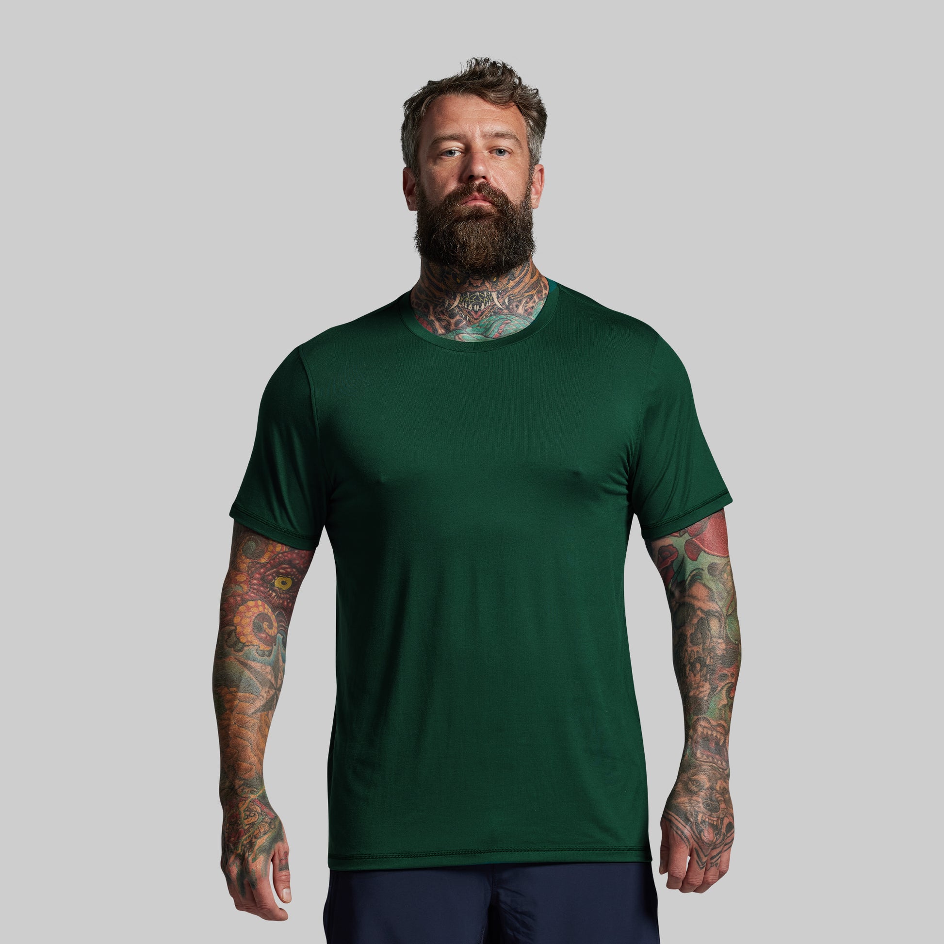 Man wearing a green t-shirt against a gray background