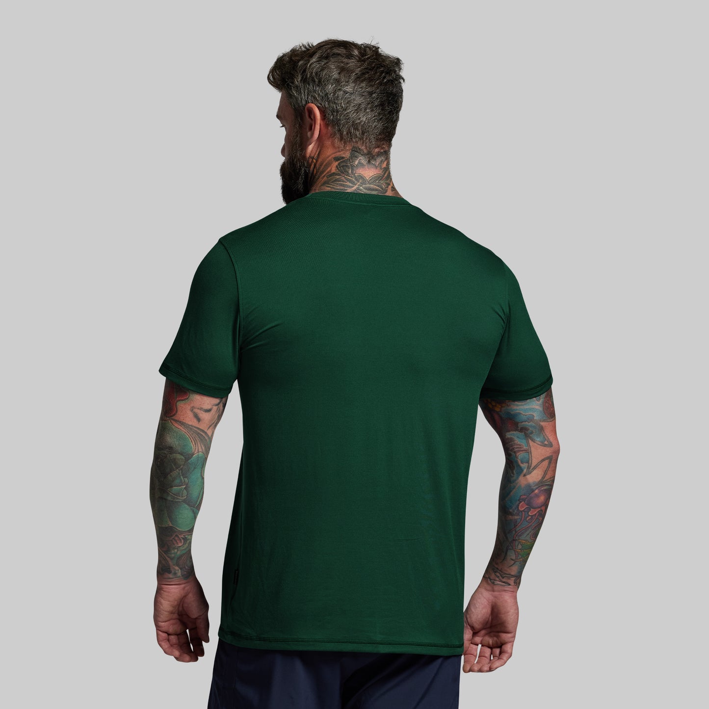 Man wearing a green t-shirt on a gray background