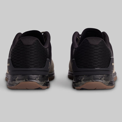 Black athletic shoes with brown soles on a light gray background