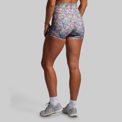Person wearing colorful patterned shorts on a gray background