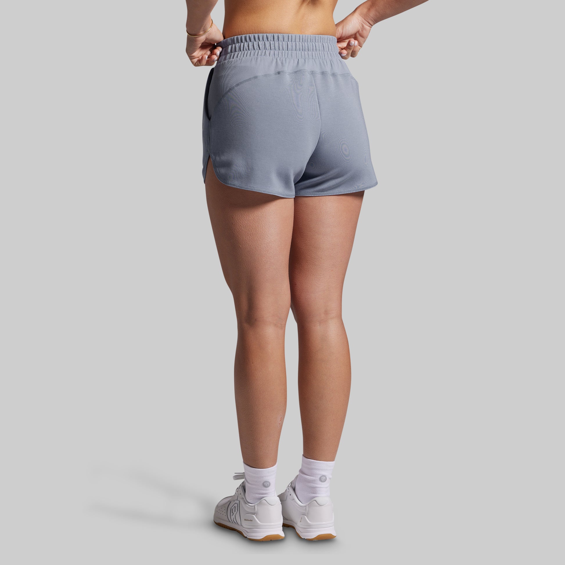 Person wearing gray lounge shorts on a plain background