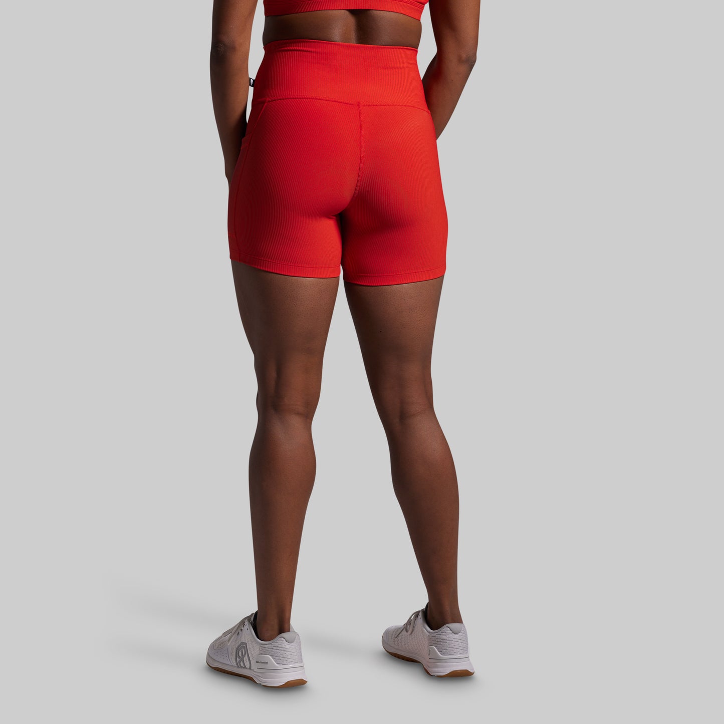 Person wearing red athletic shorts on a gray background