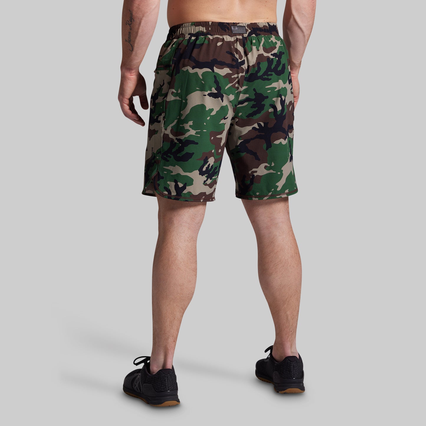 Person wearing camouflage shorts on a gray background