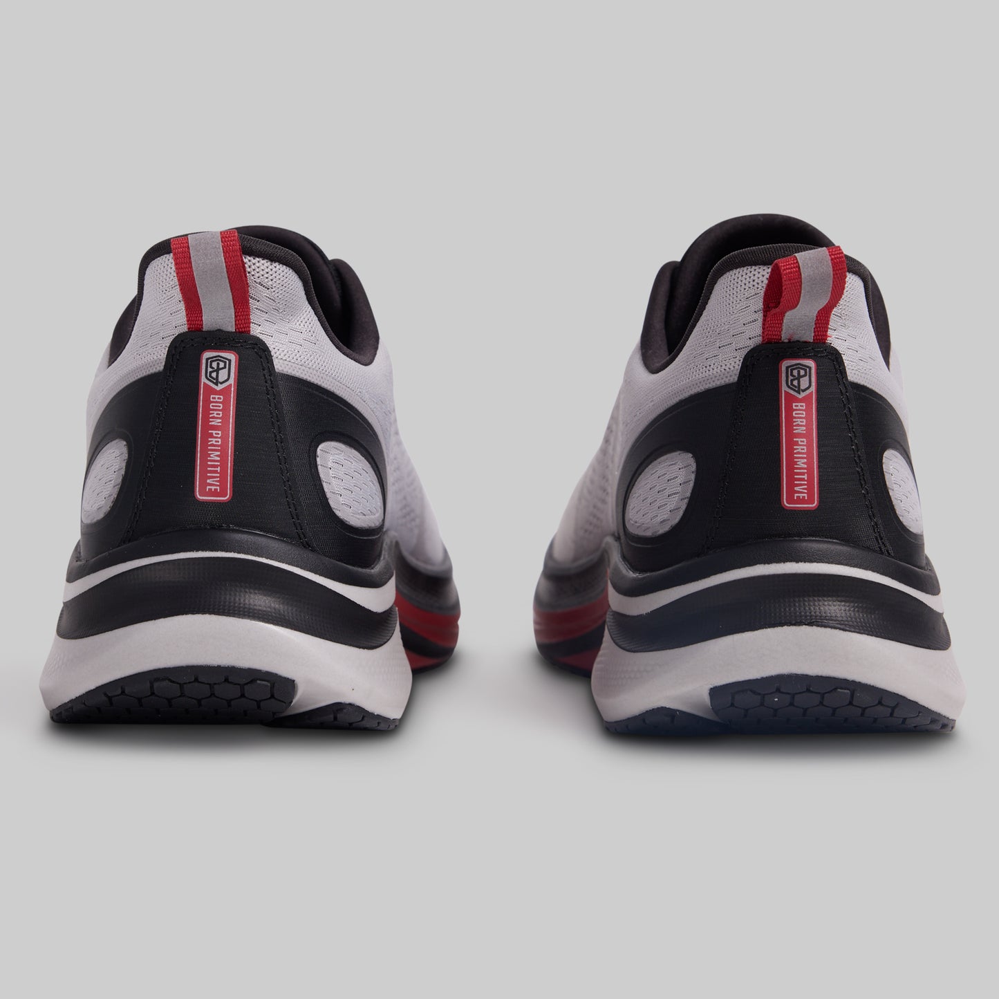 Pair of black, white, and red athletic shoes on a light gray background