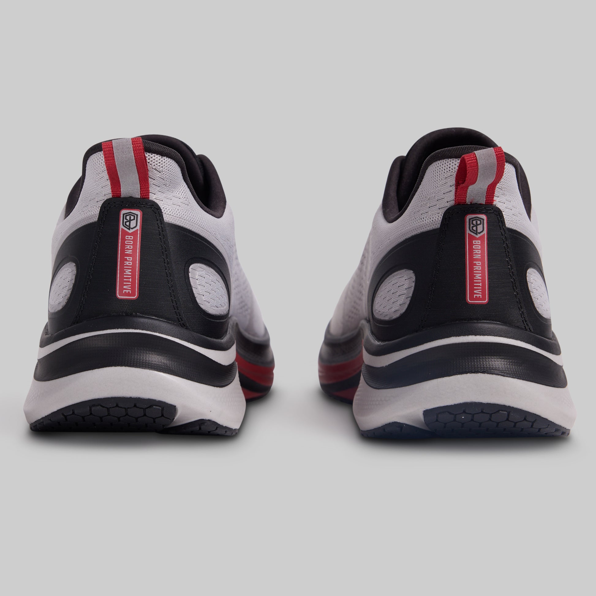 Pair of black, white, and red athletic shoes on a light gray background
