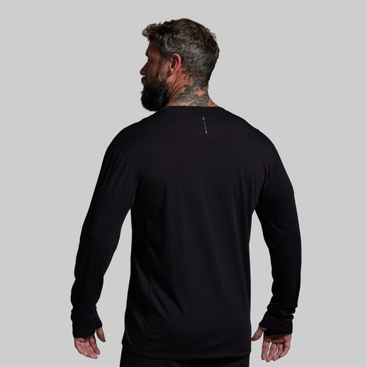 Man wearing a black long-sleeve shirt on a gray background