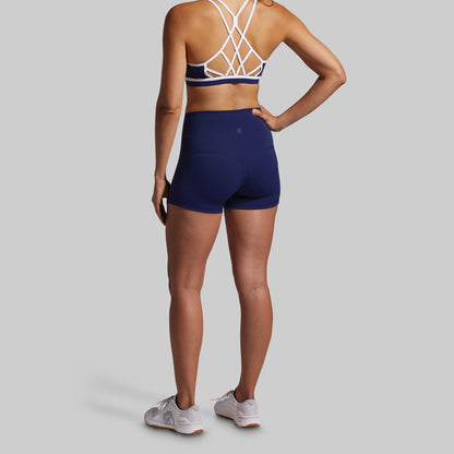 Person wearing a blue sports bra and shorts set on a gray background