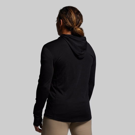 Person wearing a black hoodie from behind on a gray background