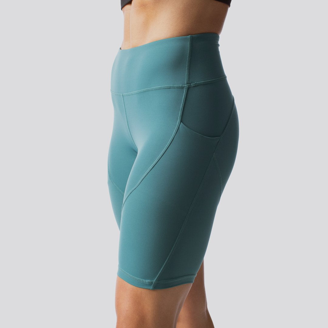 Teal athletic shorts on a plain background